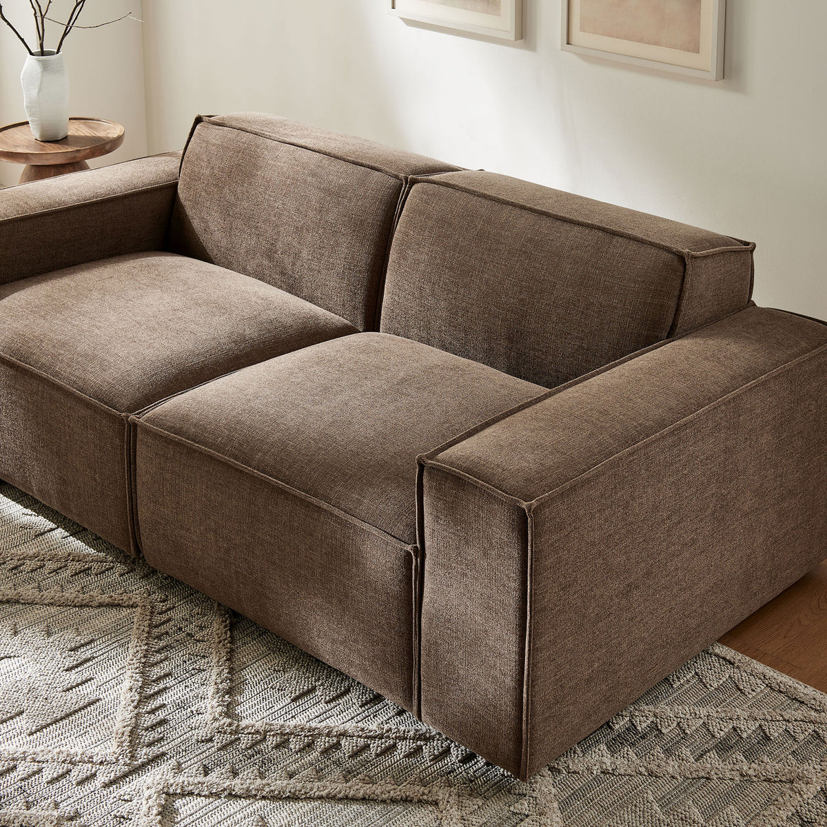 Mocha modular loveseat styled in a warm living room with textured area rug and modern wood accent tables || EEI-7403-MOC || front_angle_room