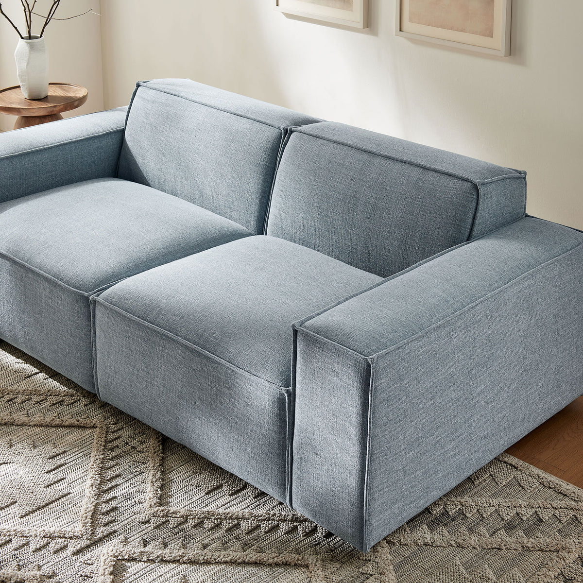 Sky blue modular loveseat anchoring a bright living room with neutral rug and artwork || EEI-7403-SKY || detail_room