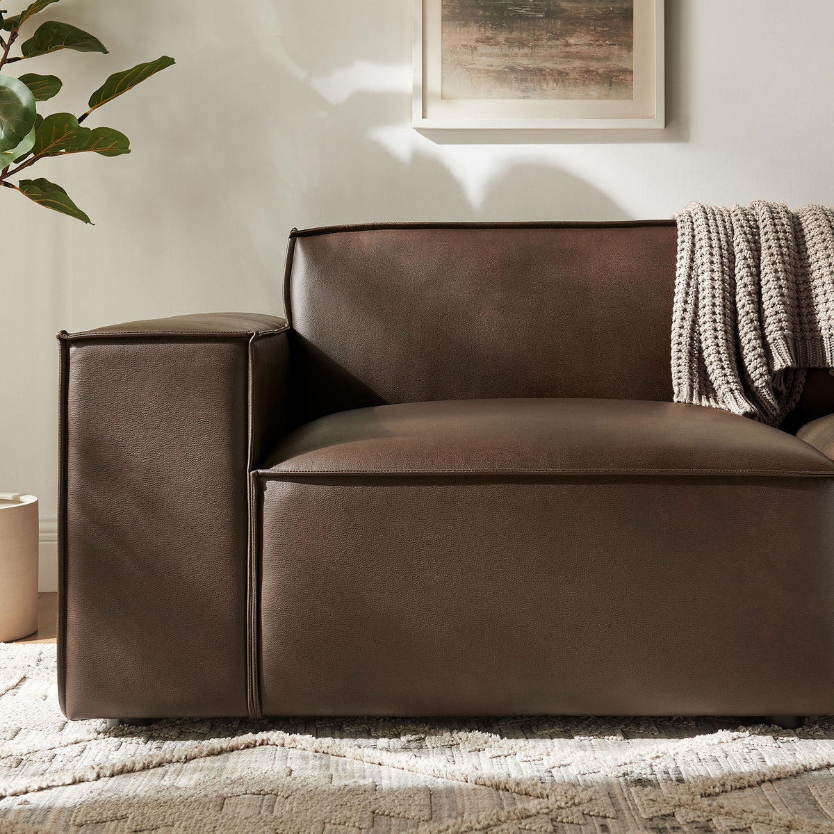 Espresso vegan leather arm and seat with French piping styled with a soft knit throw. || EEI-7404-ESP || detail_room