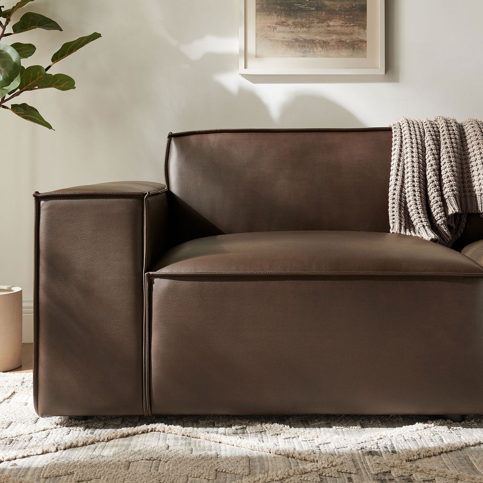 Espresso vegan leather arm and seat with French piping styled with a soft knit throw. || EEI-7404-ESP || detail_room