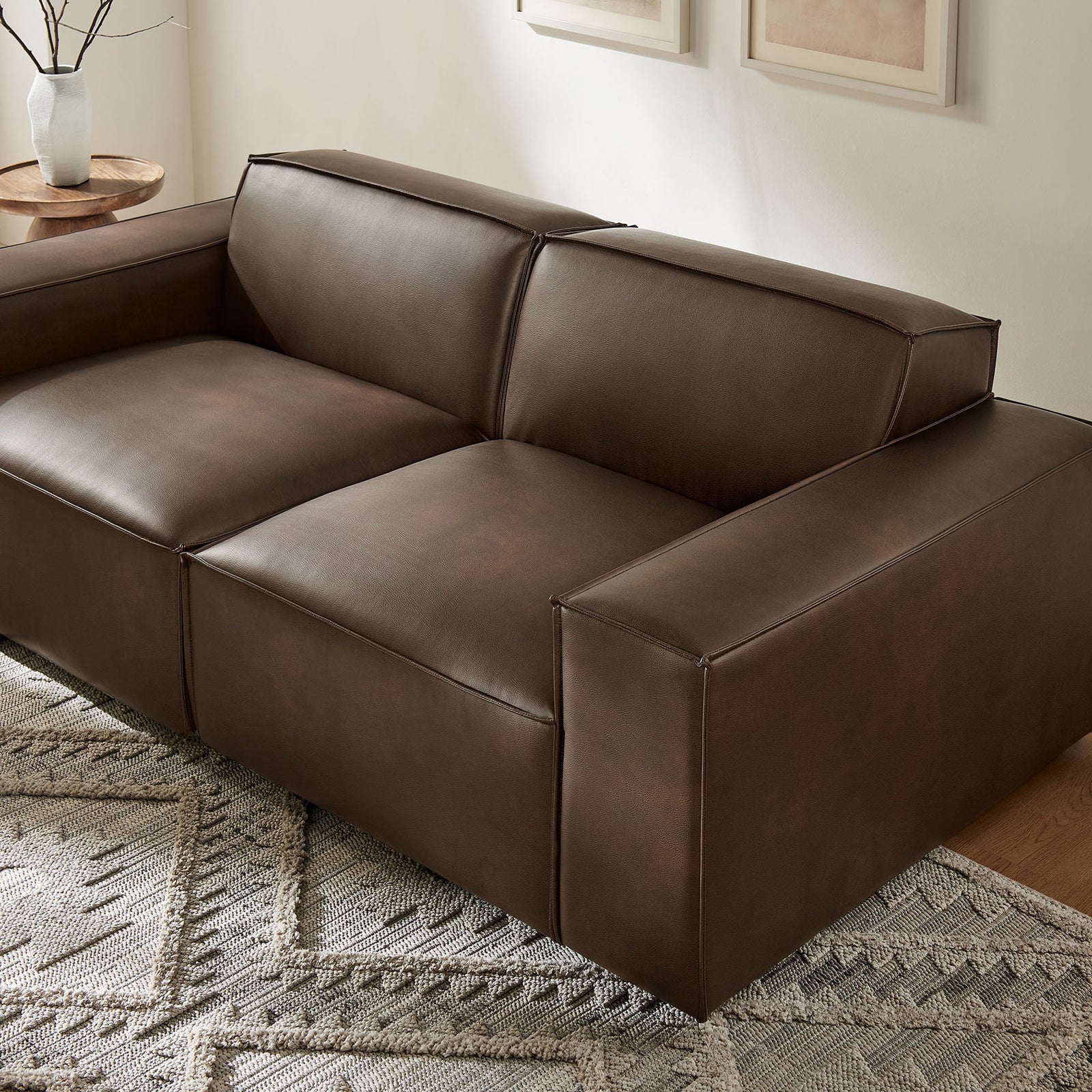 Espresso vegan leather modular loveseat styled with a textured rug and warm wood table. || EEI-7404-ESP || front_angle_room