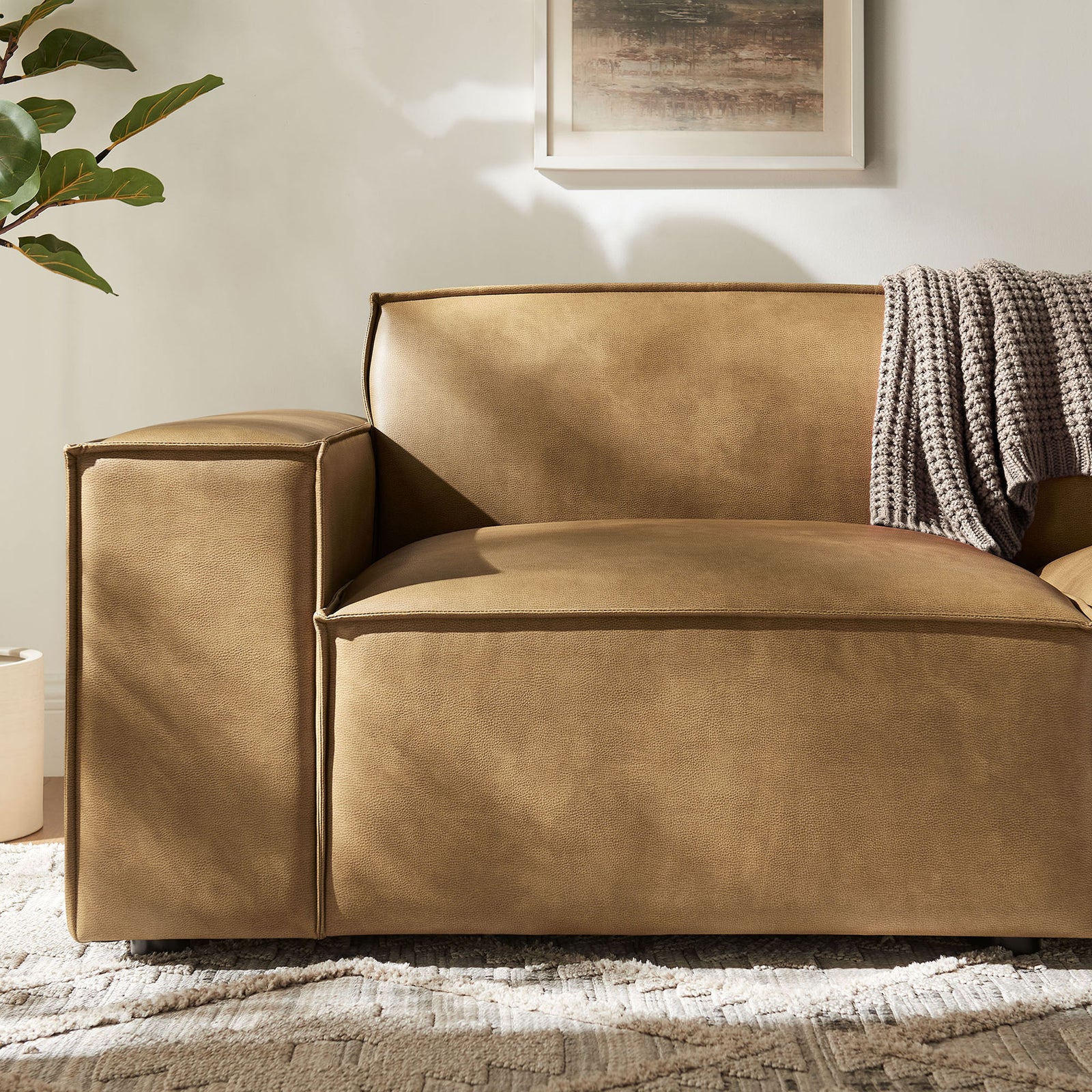 Cozy corner of the toast vegan leather loveseat with layered textures and a soft knitted throw. || EEI-7404-TST || detail_room