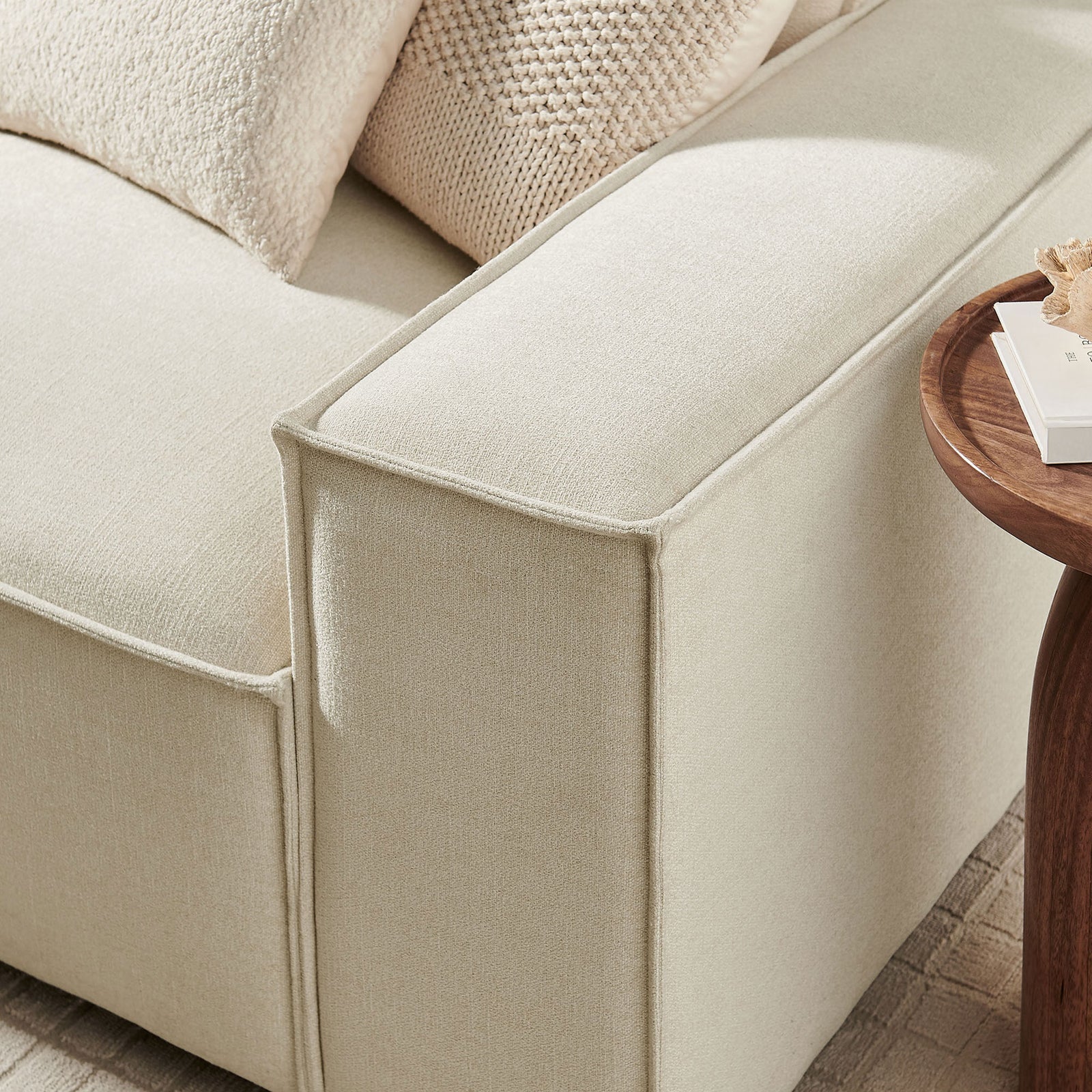 Close up of ecru modular sofa arm showing soft performance fabric and tailored French piping trim || EEI-7407-ECR || detail_room