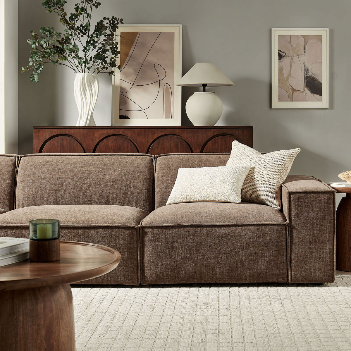 Mocha modular sofa styled in a warm living room with neutral artwork, wood accents, and soft pillows. || EEI-7407-MOC || detail_room