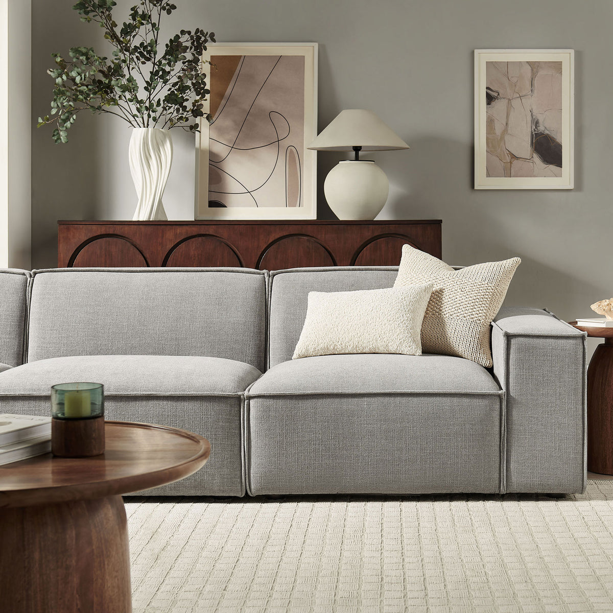Modern living room scene featuring the pewter modular sofa styled with textured pillows and warm wood accents. || EEI-7407-PEW || detail_room