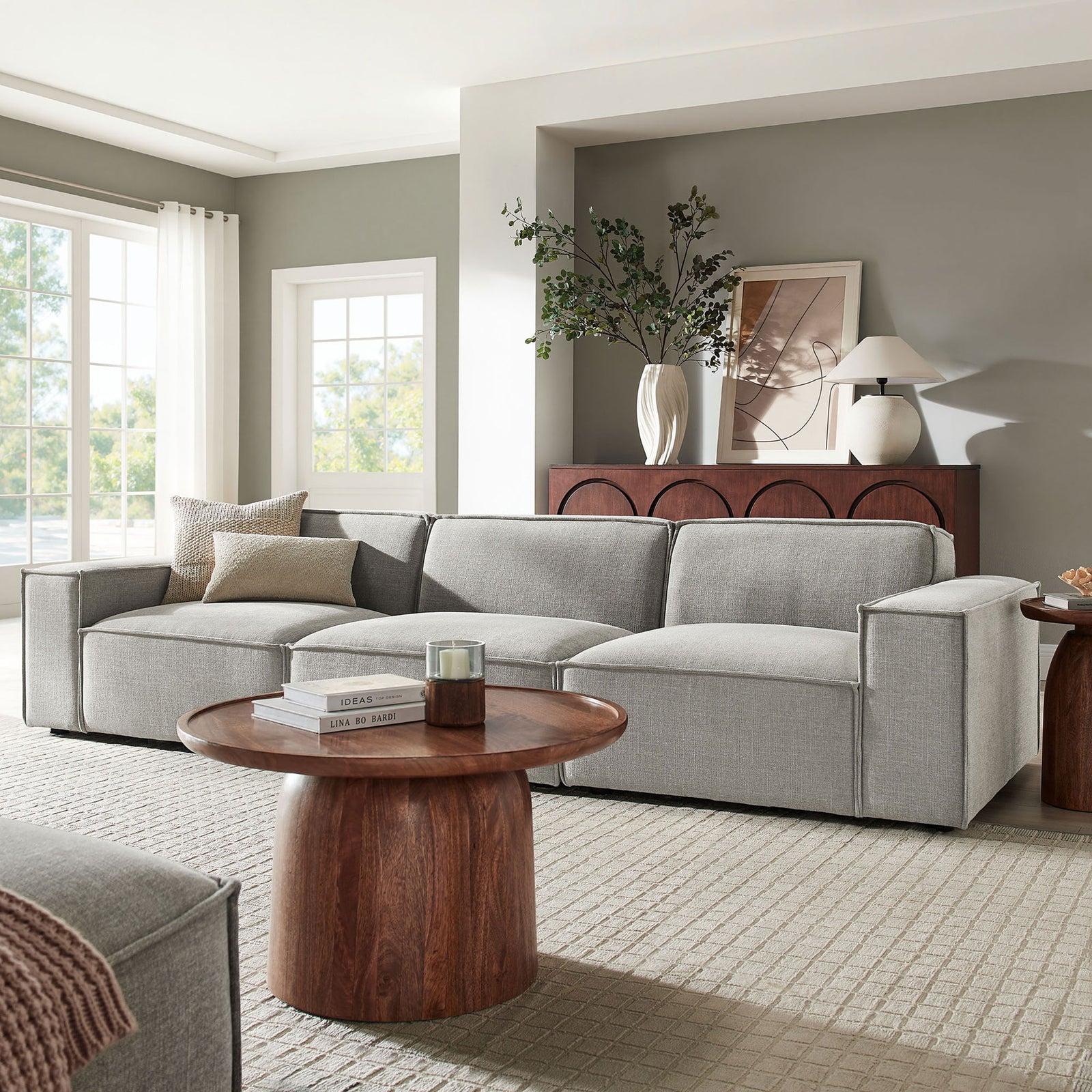 Restore modular sectional in pewter fabric anchoring a bright living room with large windows and a wood coffee table. || EEI-7407-PEW || front_angle_room