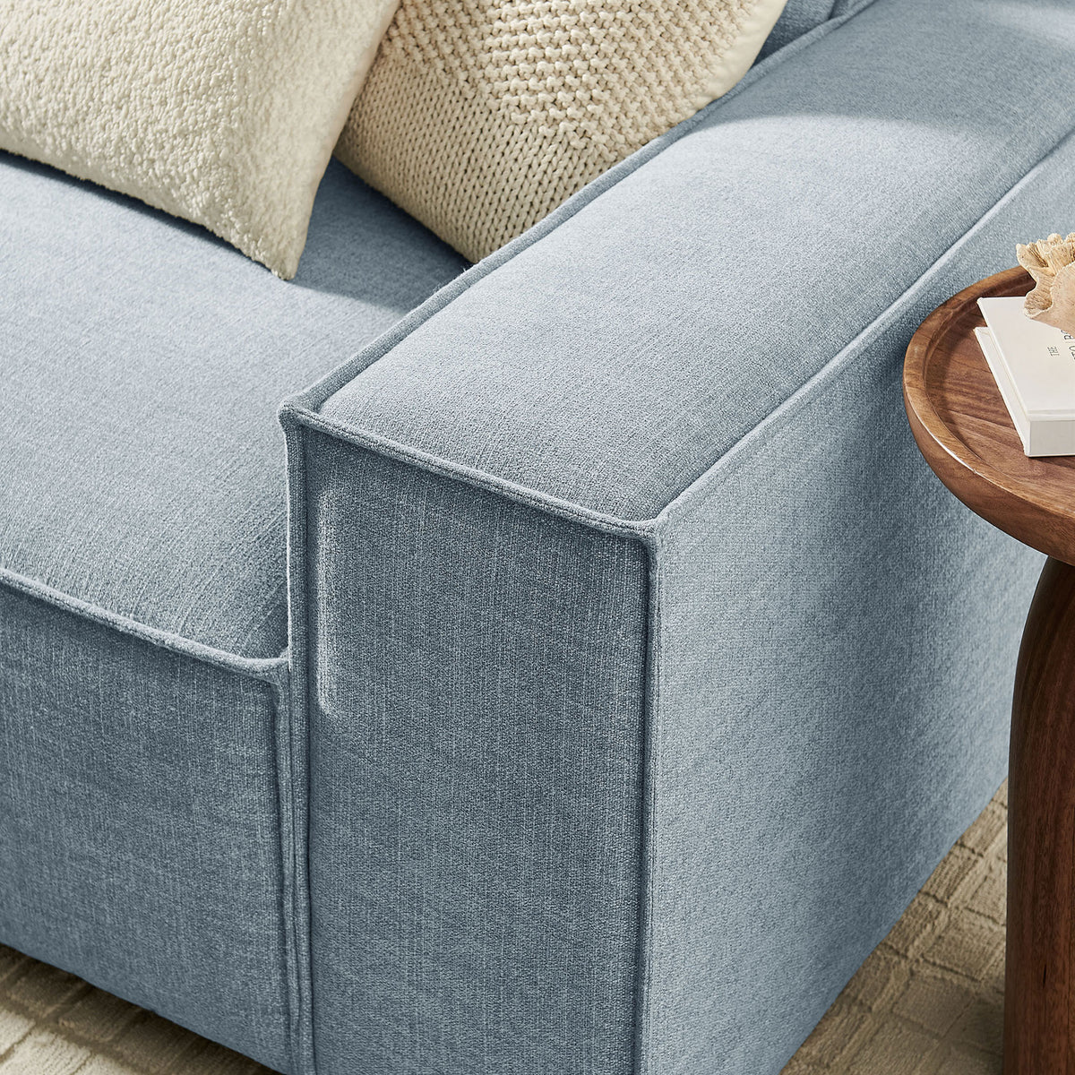 Sky blue sofa arm with crisp piping, soft textured upholstery, and cozy knit accent pillows || EEI-7407-SKY || detail_room