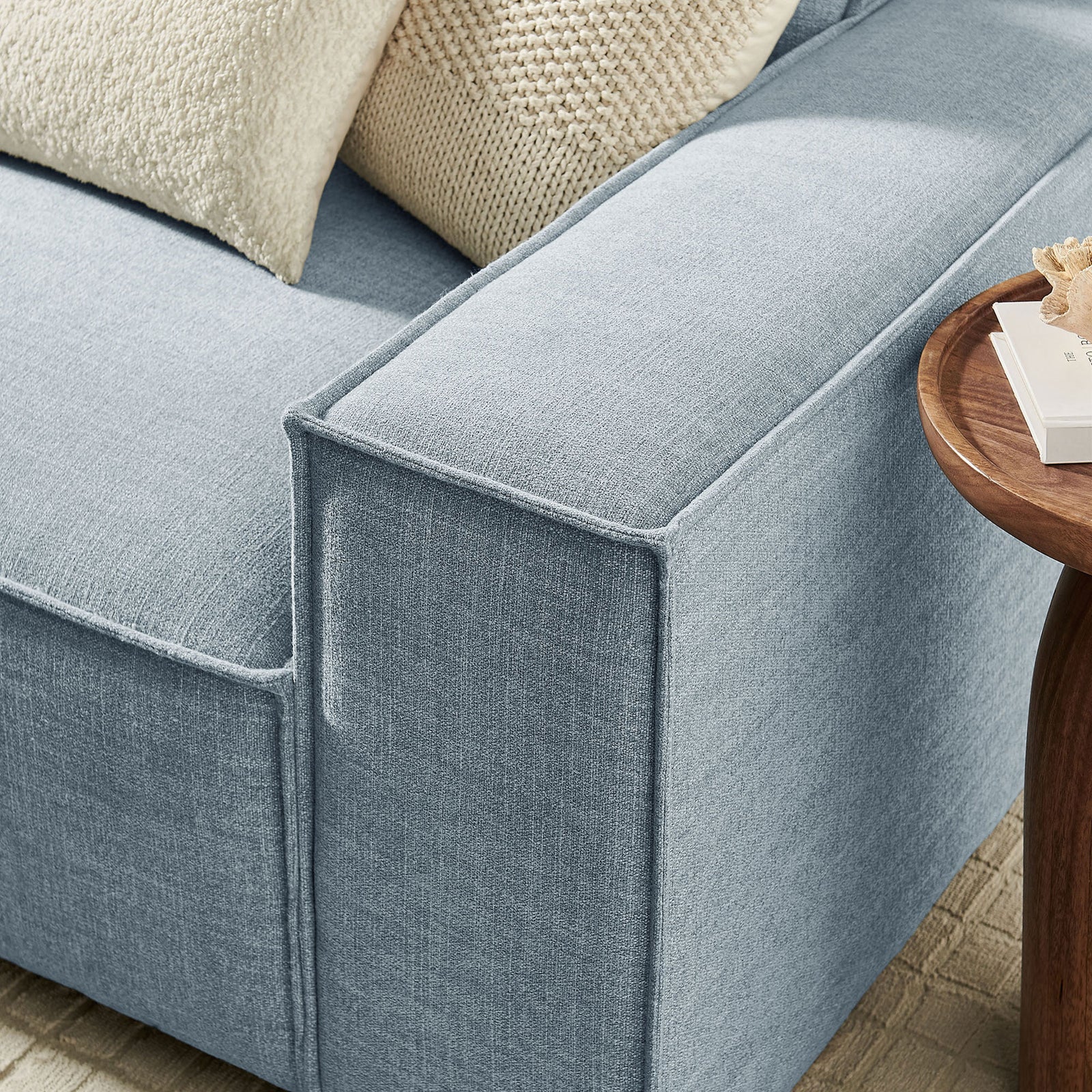 Sky blue sofa arm with crisp piping, soft textured upholstery, and cozy knit accent pillows || EEI-7407-SKY || detail_room