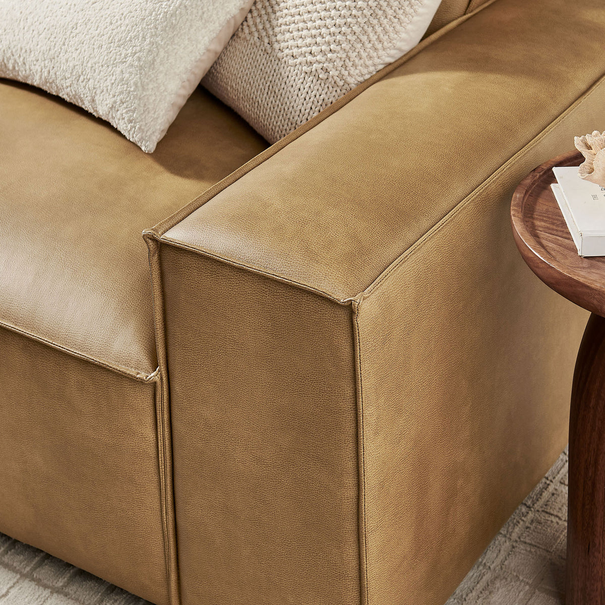 Close-up of the wide track arm showcasing the smooth vegan leather upholstery and tailored piping. || EEI-7408-TST || detail_room