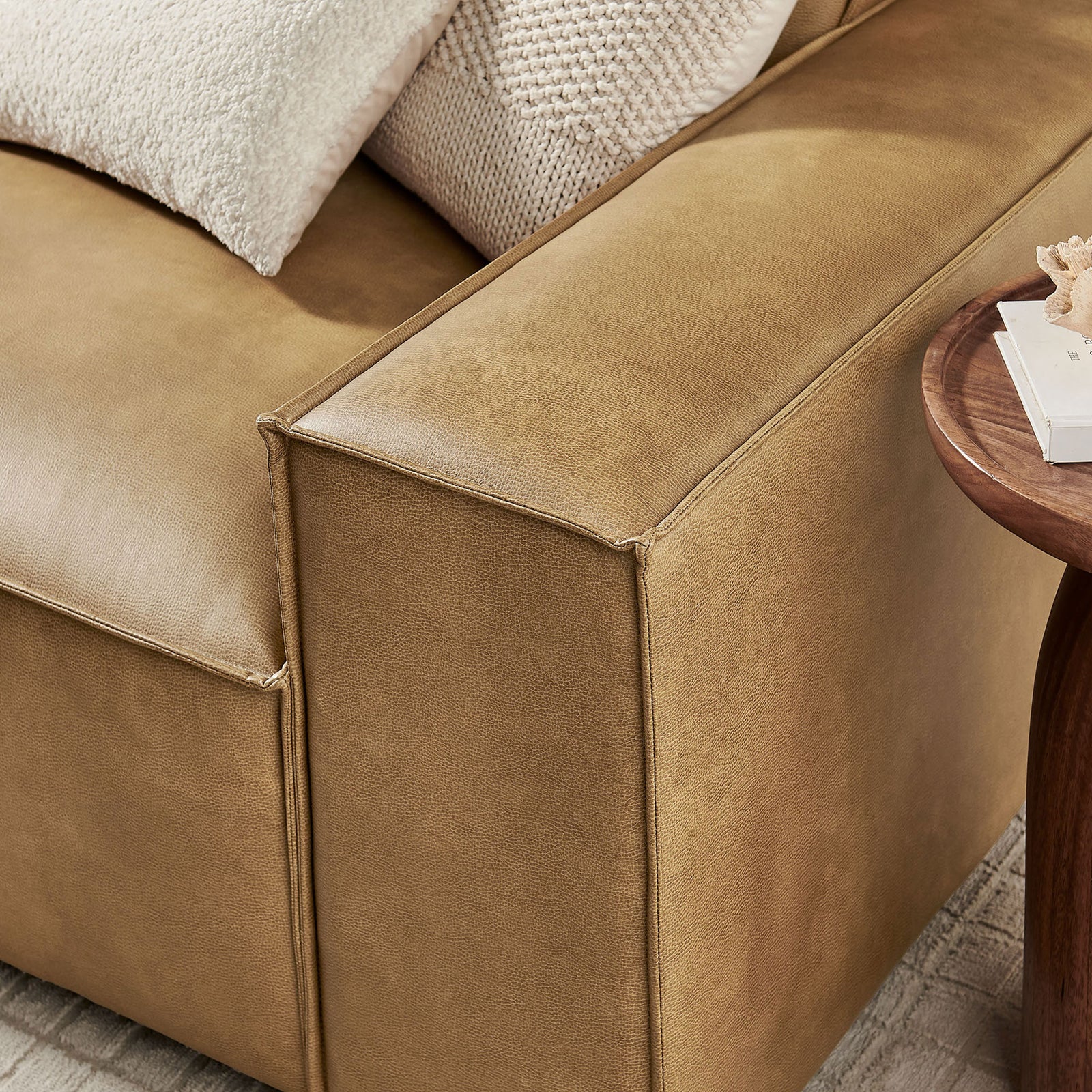 Close-up of the wide track arm showcasing the smooth vegan leather upholstery and tailored piping. || EEI-7408-TST || detail_room