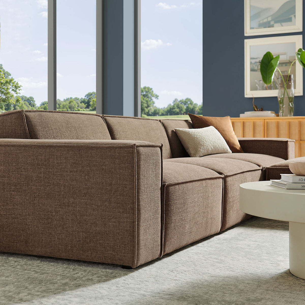 Mocha modular sectional styled in a bright living room, showing tailored arms and plush performance cushions. || EEI-7409-MOC || detail_room