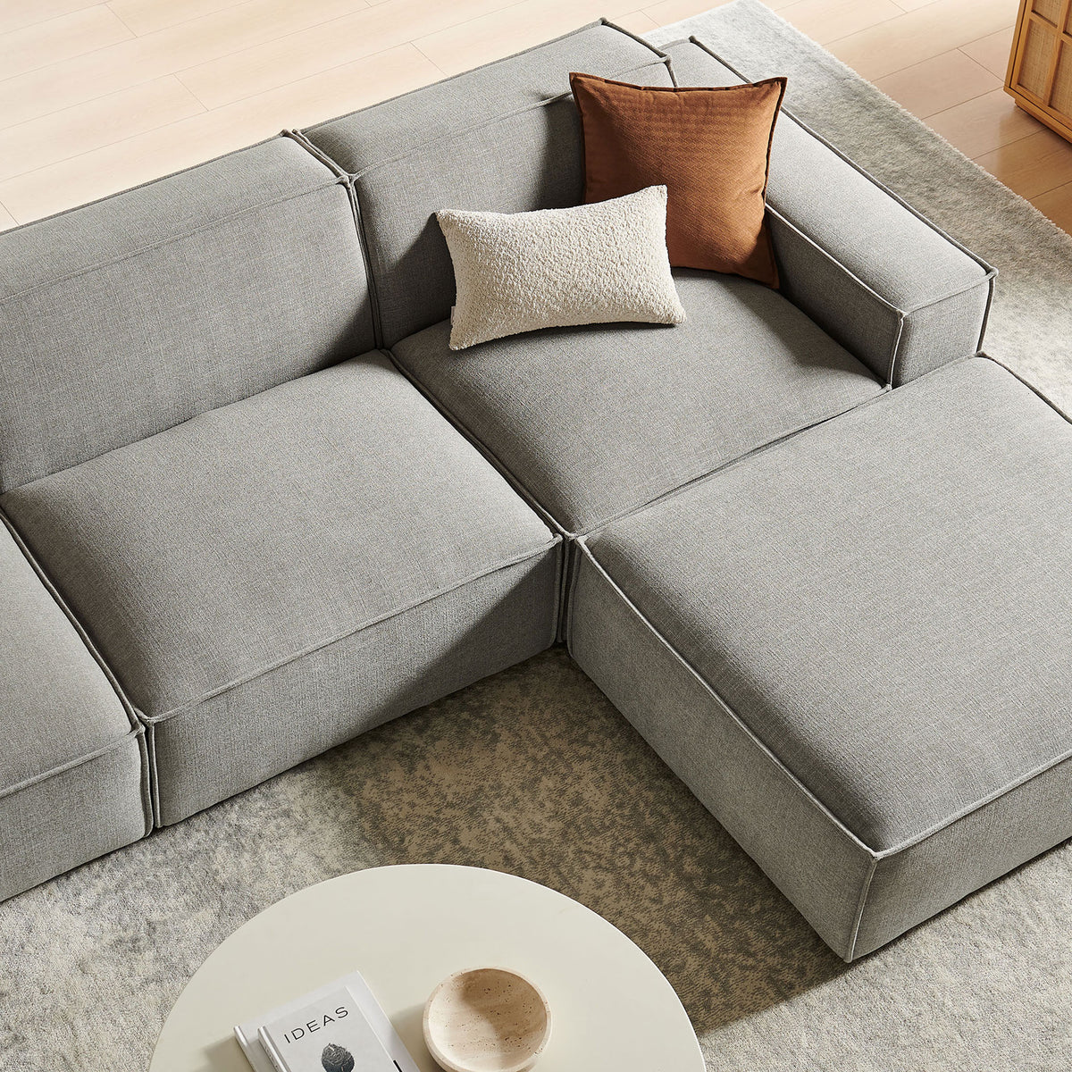 Cozy corner of the Restore sectional with layered pillows on the chaise and ottoman || EEI-7409-PEW || detail_room