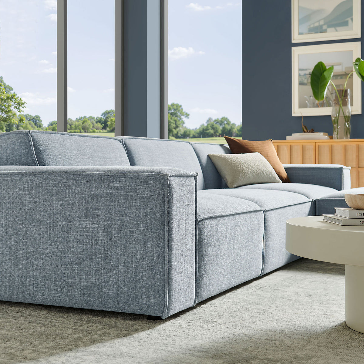 Sky blue sectional styled in a bright living room, featuring wide armrests and generously padded seat cushions || EEI-7409-SKY || detail_room