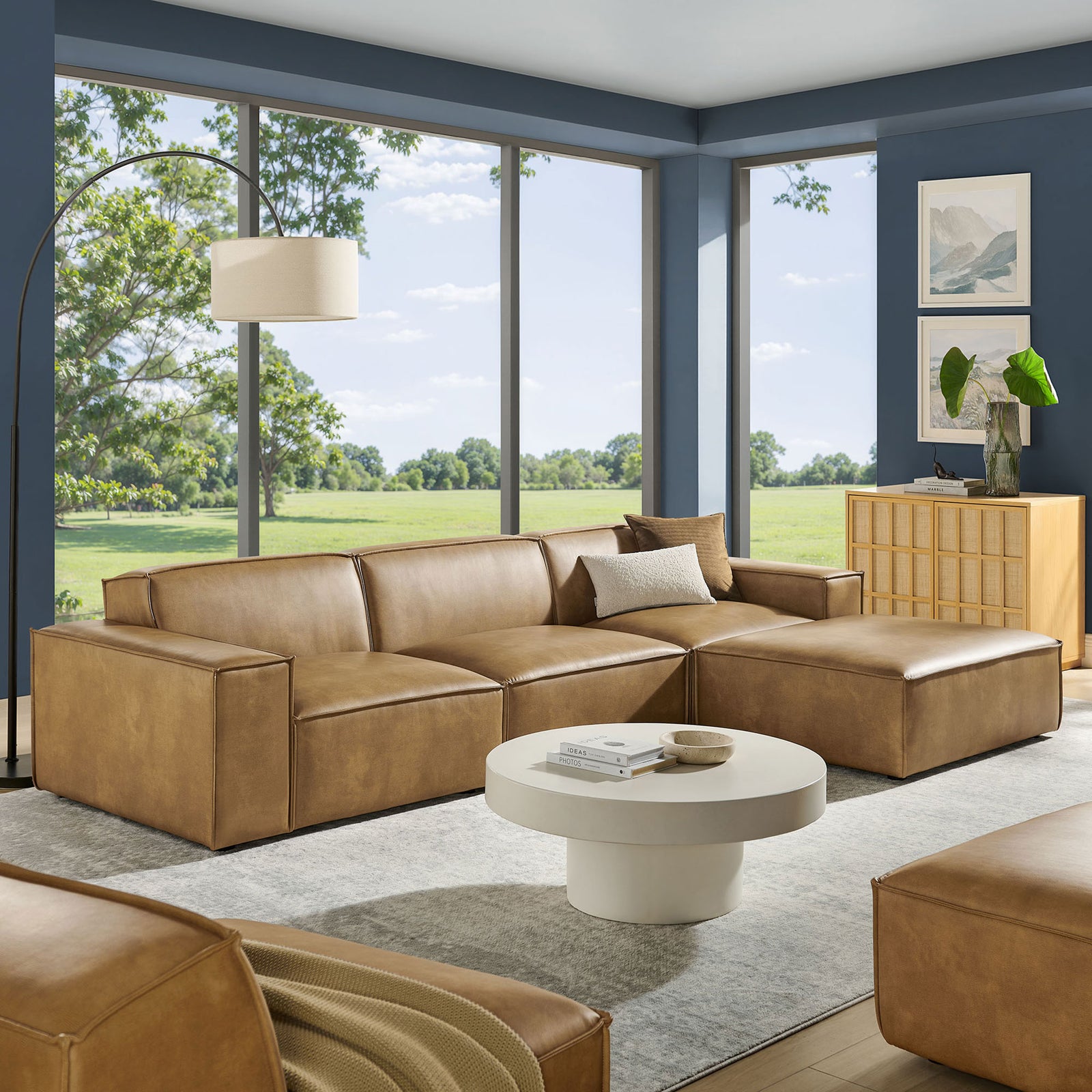 Spacious toast vegan leather modular sectional with ottoman anchoring a bright windowed living space || EEI-7410-TST || front_angle_room
