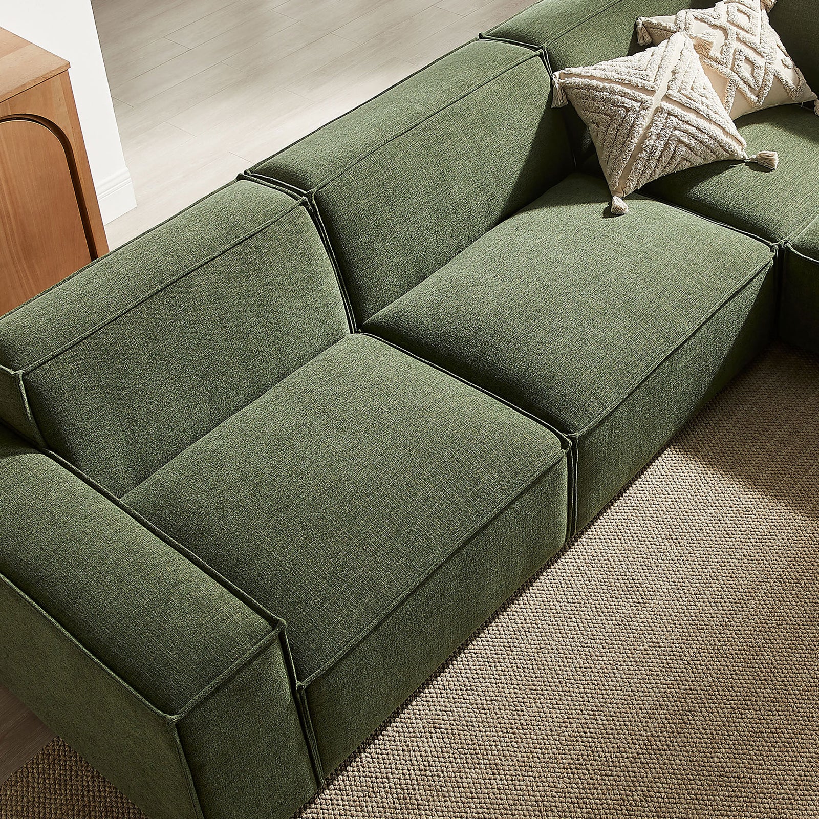 Deep foliage green modular seats styled with textured accent pillows to emphasize comfort and relaxed lounge appeal. || EEI-7411-FOL || detail_room