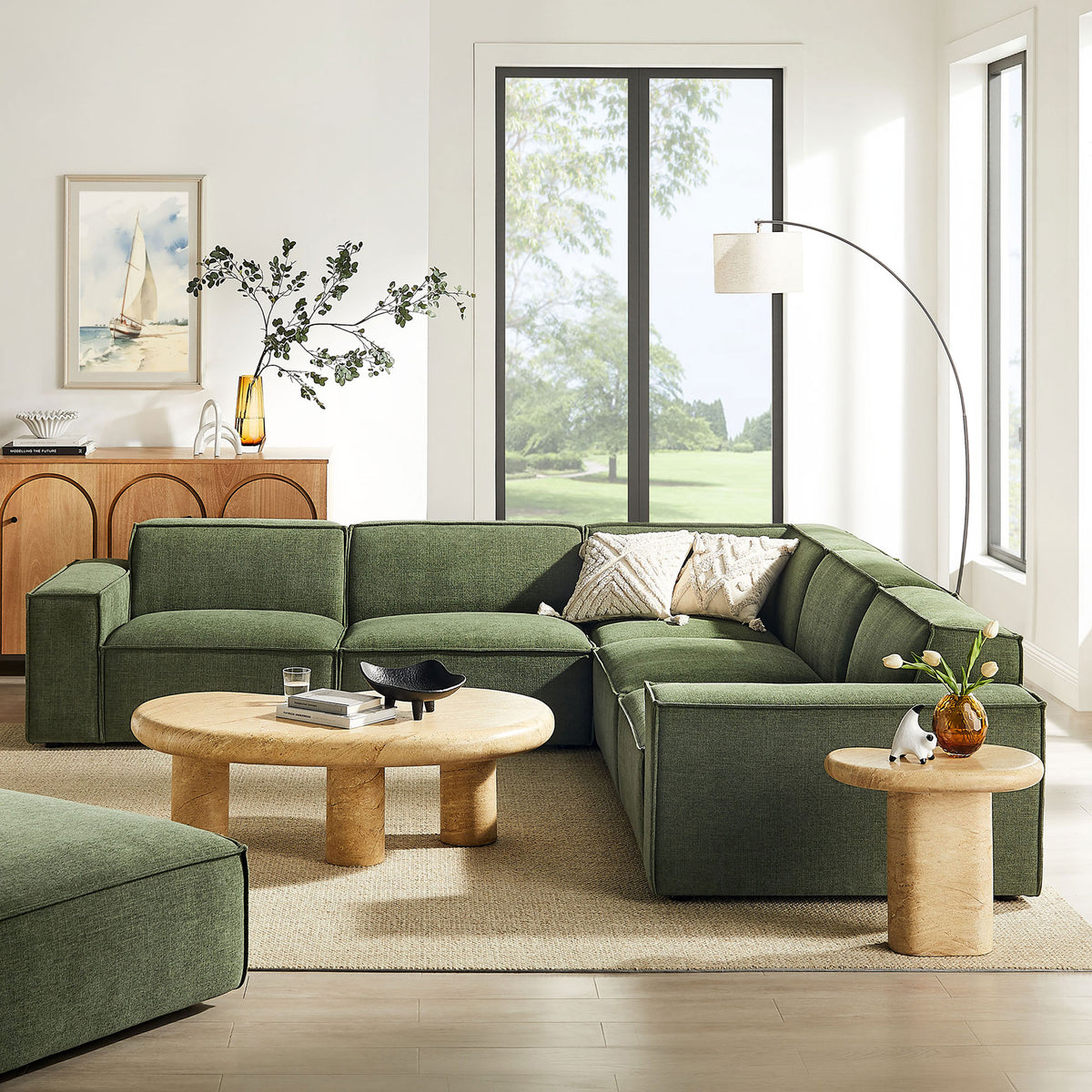 Foliage green Restore sectional anchoring a bright modern living room with round wood tables and airy decor. || EEI-7411-FOL || front_angle_room