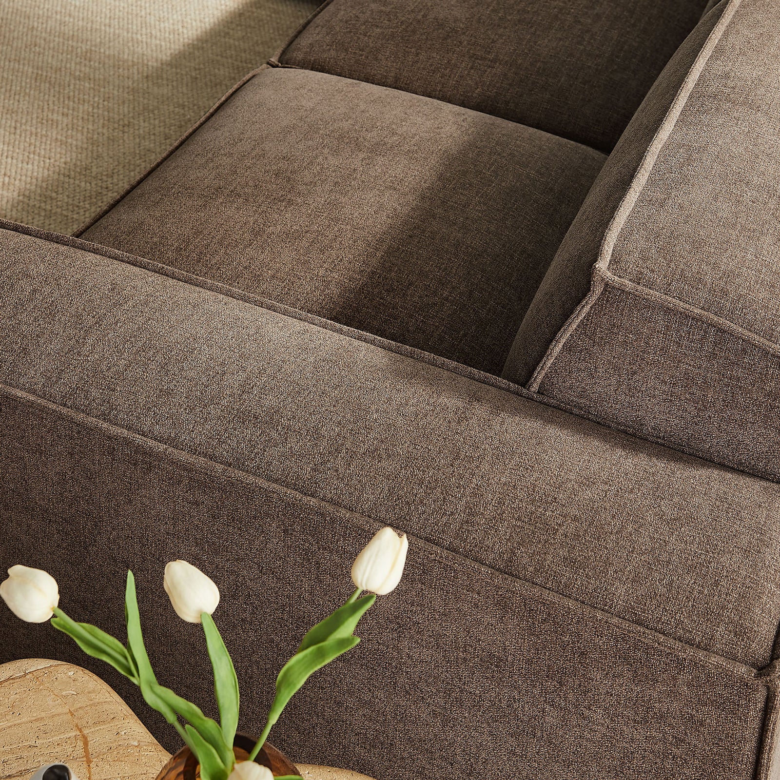 Mocha performance fabric upholstery with French piping and soft, supportive cushioning along the arm and seat || EEI-7411-MOC || detail_room