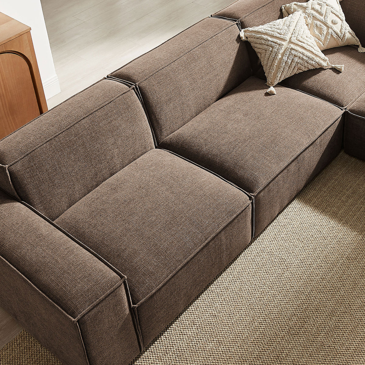 Deep mocha seat and back cushions styled with textured accent pillows in a warm, contemporary living room || EEI-7411-MOC || detail_room