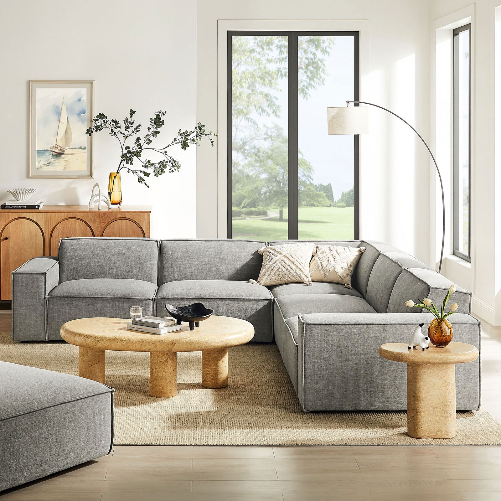 Pewter modular L-shaped sectional anchors a bright living room with neutral rug and warm wood accents || EEI-7411-PEW || front_angle_room