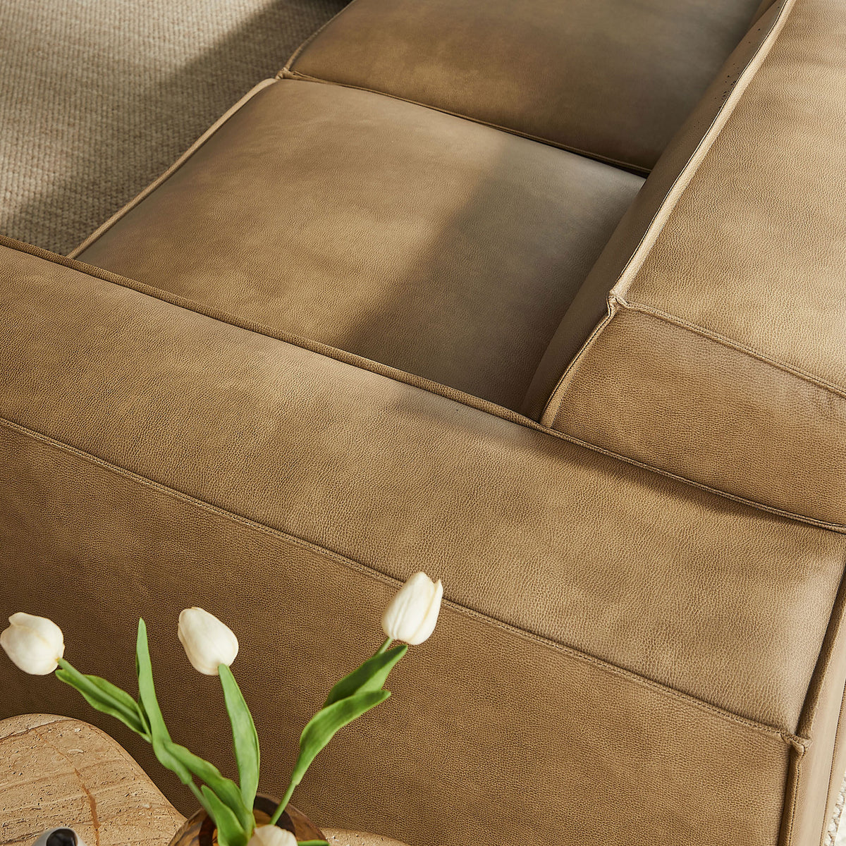Toast vegan leather seat cushions showcasing subtle texture next to a decorative side table || EEI-7412-TST || detail_room