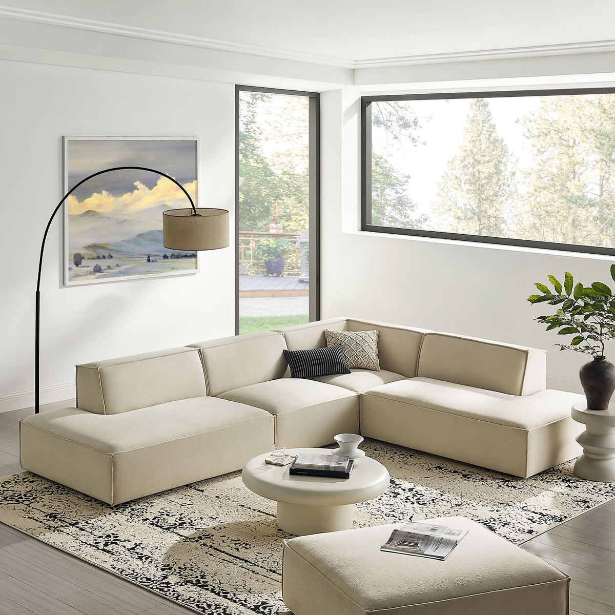 Ecru modular sectional anchors a bright living room with modern rug, round coffee table, and floor lamp. || EEI-7413-ECR || front_angle_room