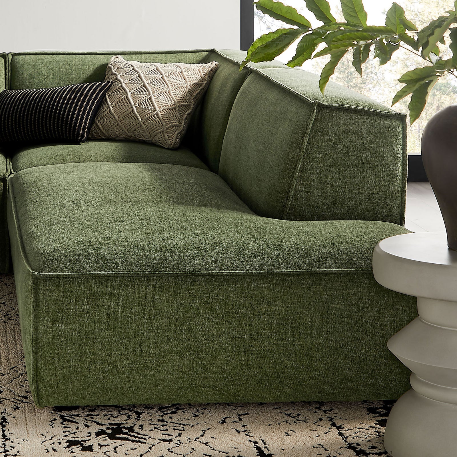 Corner of the green modular sectional styled with accent pillows for relaxed lounge comfort. || EEI-7413-FOL || detail_room