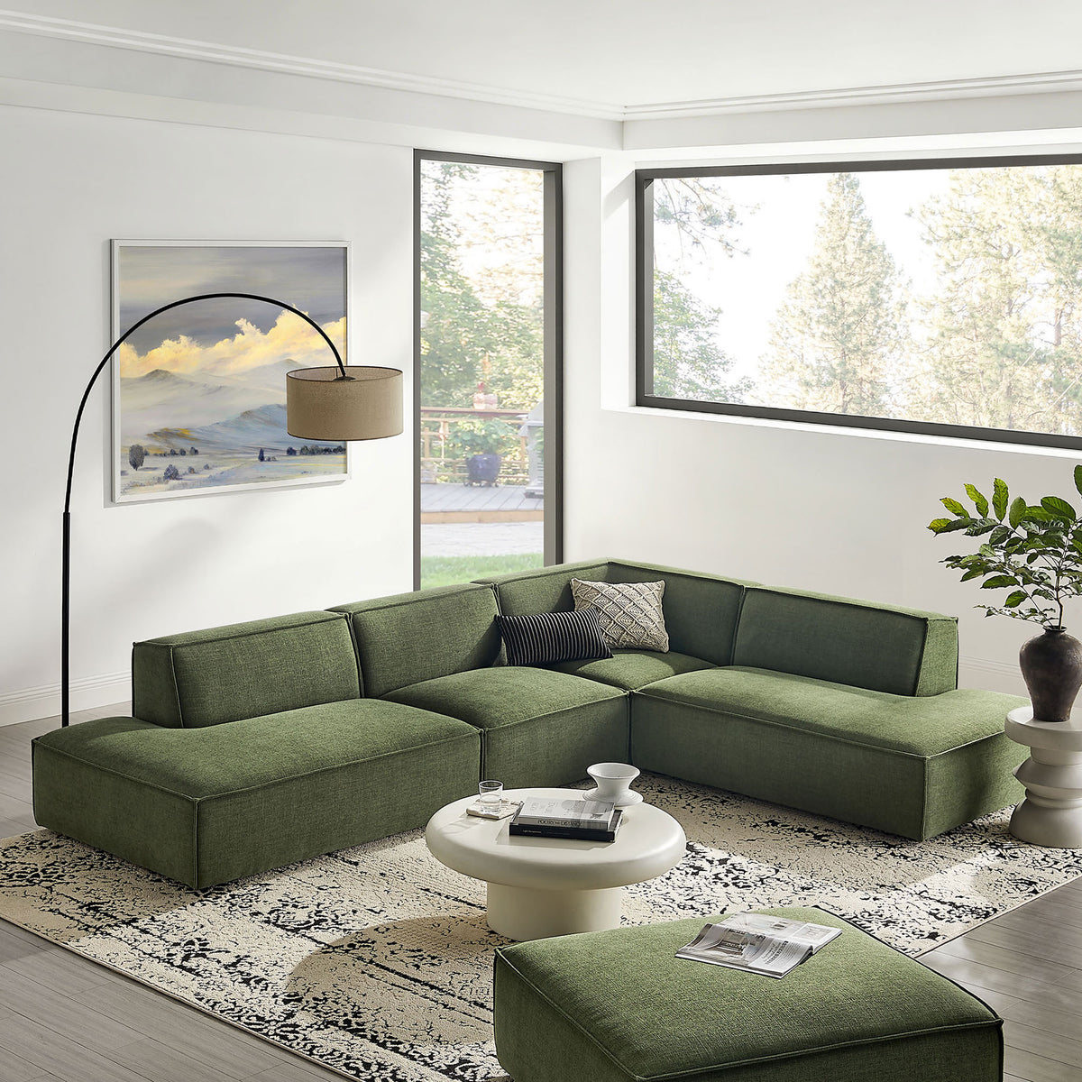Restore foliage green modular sectional arranged in a bright living room with rug and coffee table. || EEI-7413-FOL || front_angle_room