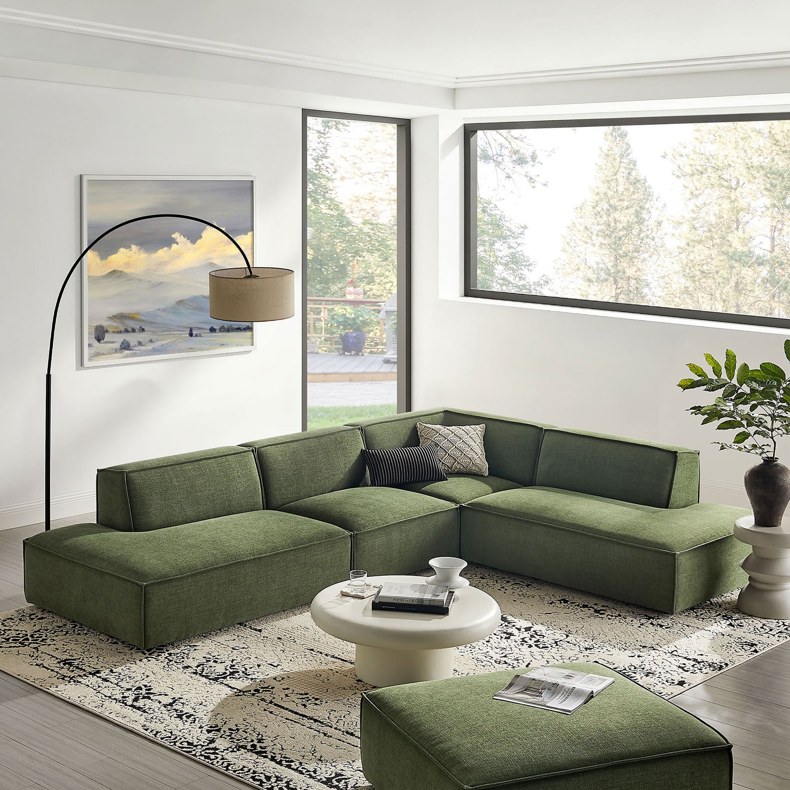 Restore foliage green modular sectional arranged in a bright living room with rug and coffee table. || EEI-7413-FOL || front_angle_room