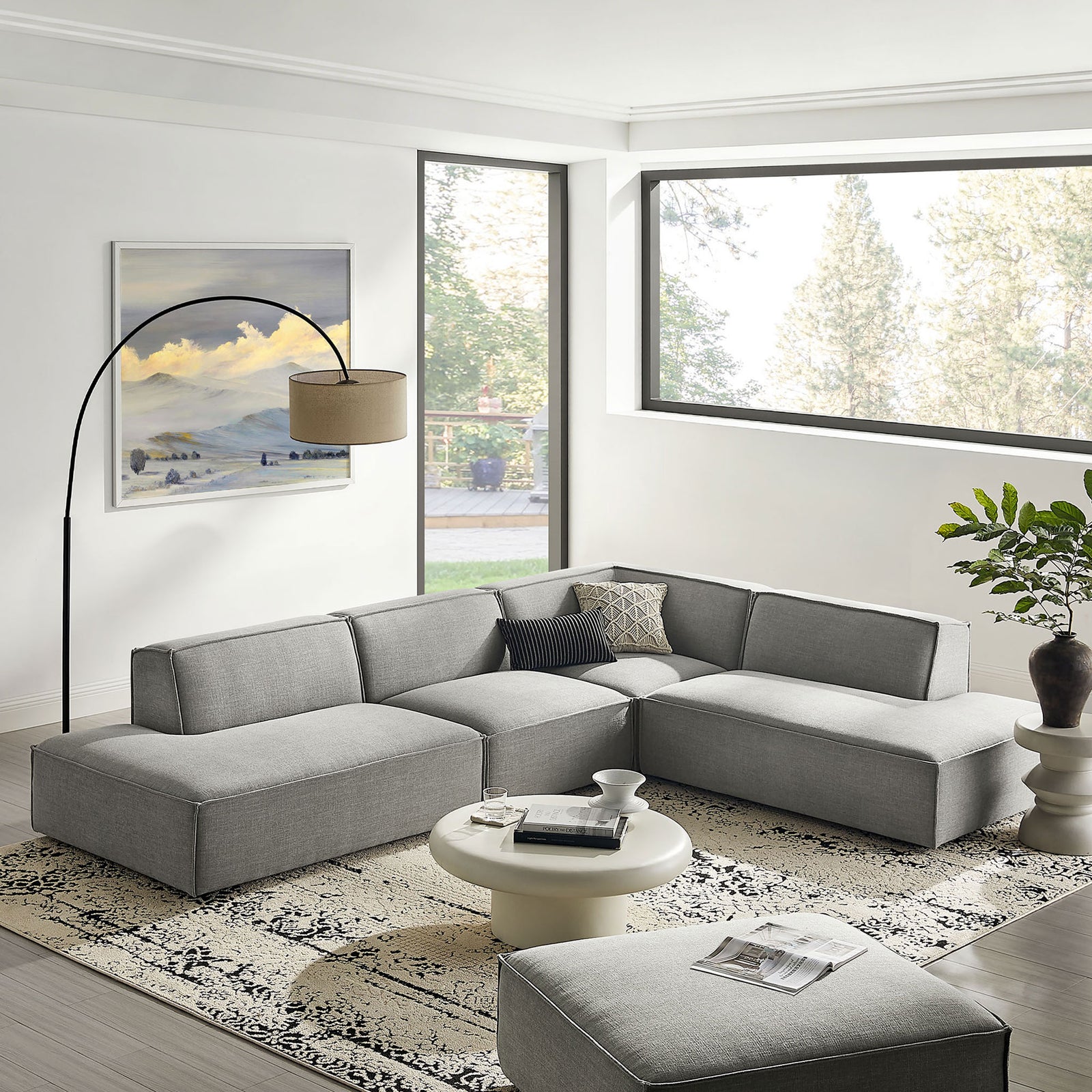 Pewter modular L-shaped sectional in bright living room with rug, round coffee table, and floor lamp || EEI-7413-PEW || front_angle_room
