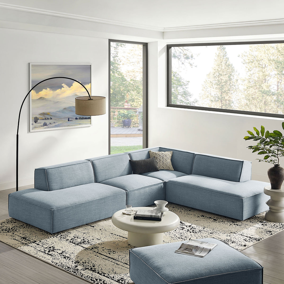 Sky blue modular sectional sofa styled in a bright living room with rug, round coffee table, and floor lamp. || EEI-7413-SKY || front_angle_room