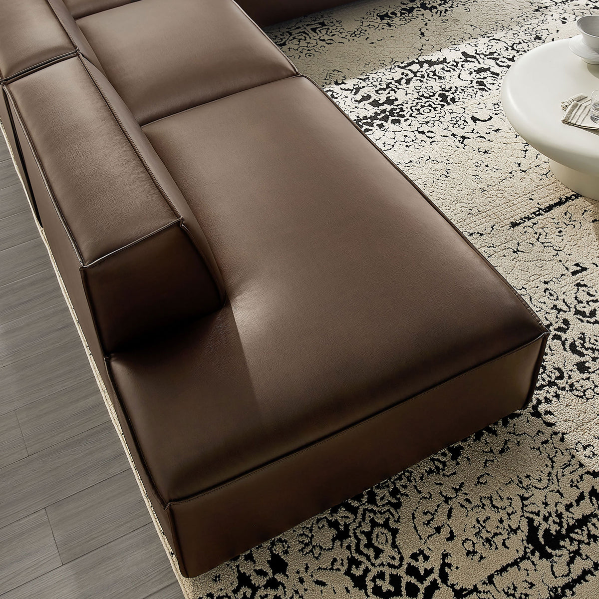 Close-up of the chaise seat showing the tailored vegan leather, French piping, and supportive cushioning || EEI-7414-ESP || detail_room