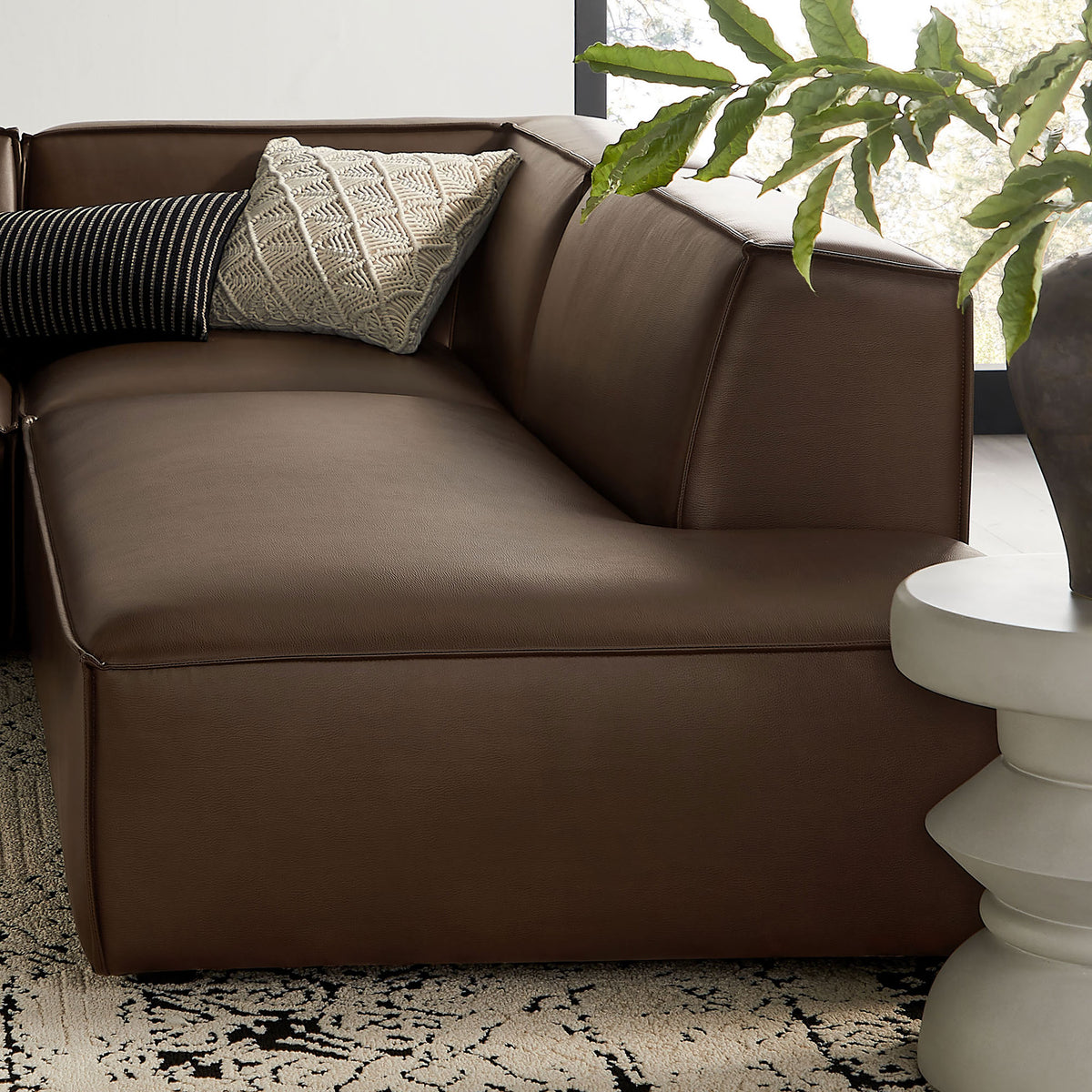 Corner module styled with textured throw pillows, emphasizing the sofa's deep seat and lounge-ready comfort || EEI-7414-ESP || detail_room