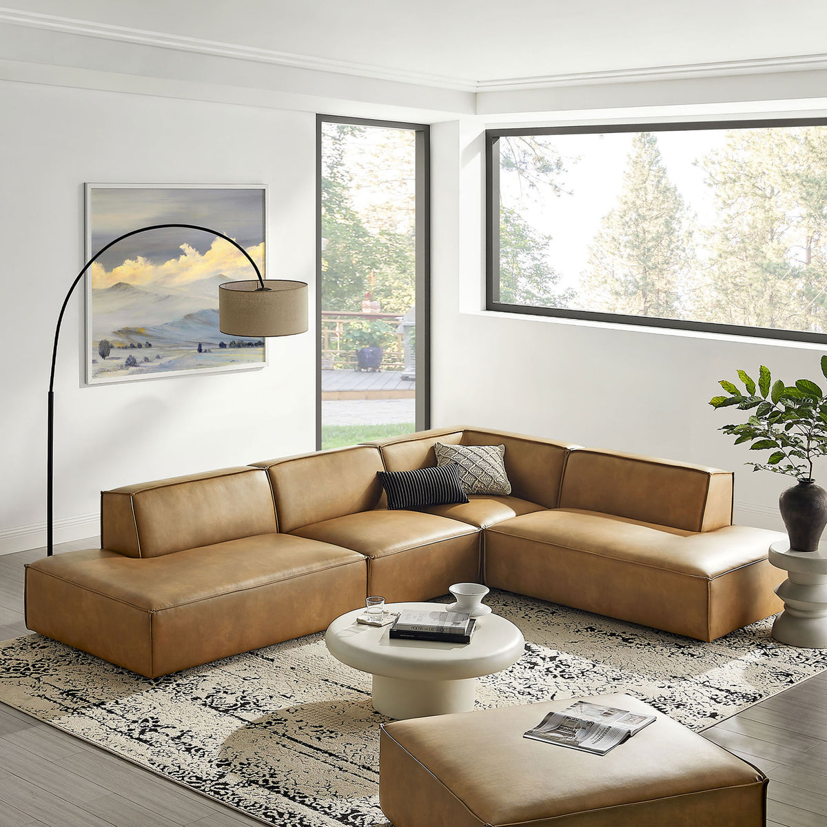 Toast vegan leather sectional anchored on a patterned rug in a bright, contemporary living room. || EEI-7414-TST || front_angle_room