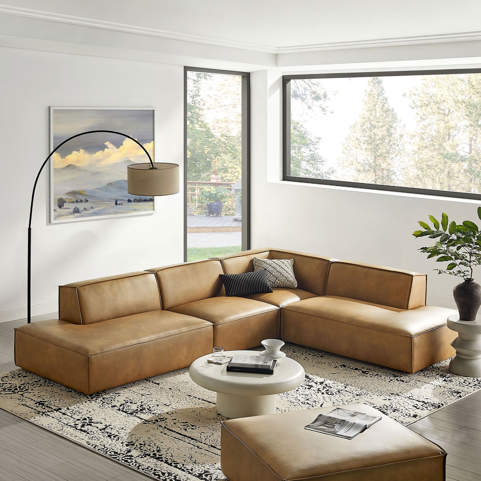 Toast vegan leather sectional anchored on a patterned rug in a bright, contemporary living room. || EEI-7414-TST || front_angle_room