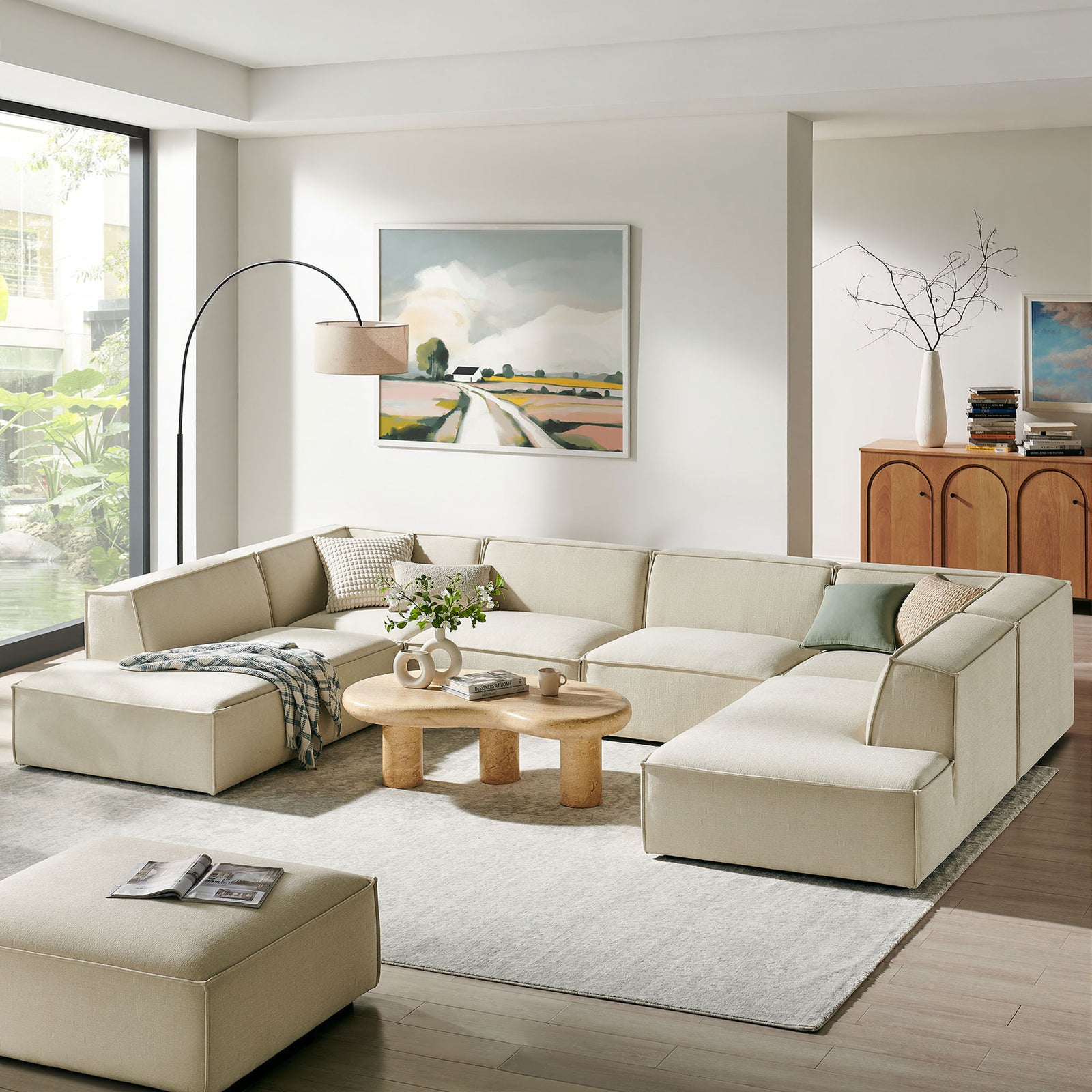 Ecru modular sectional anchors a bright living room with dual chaises, round wood tables, and serene decor. || EEI-7415-ECR || front_angle_room