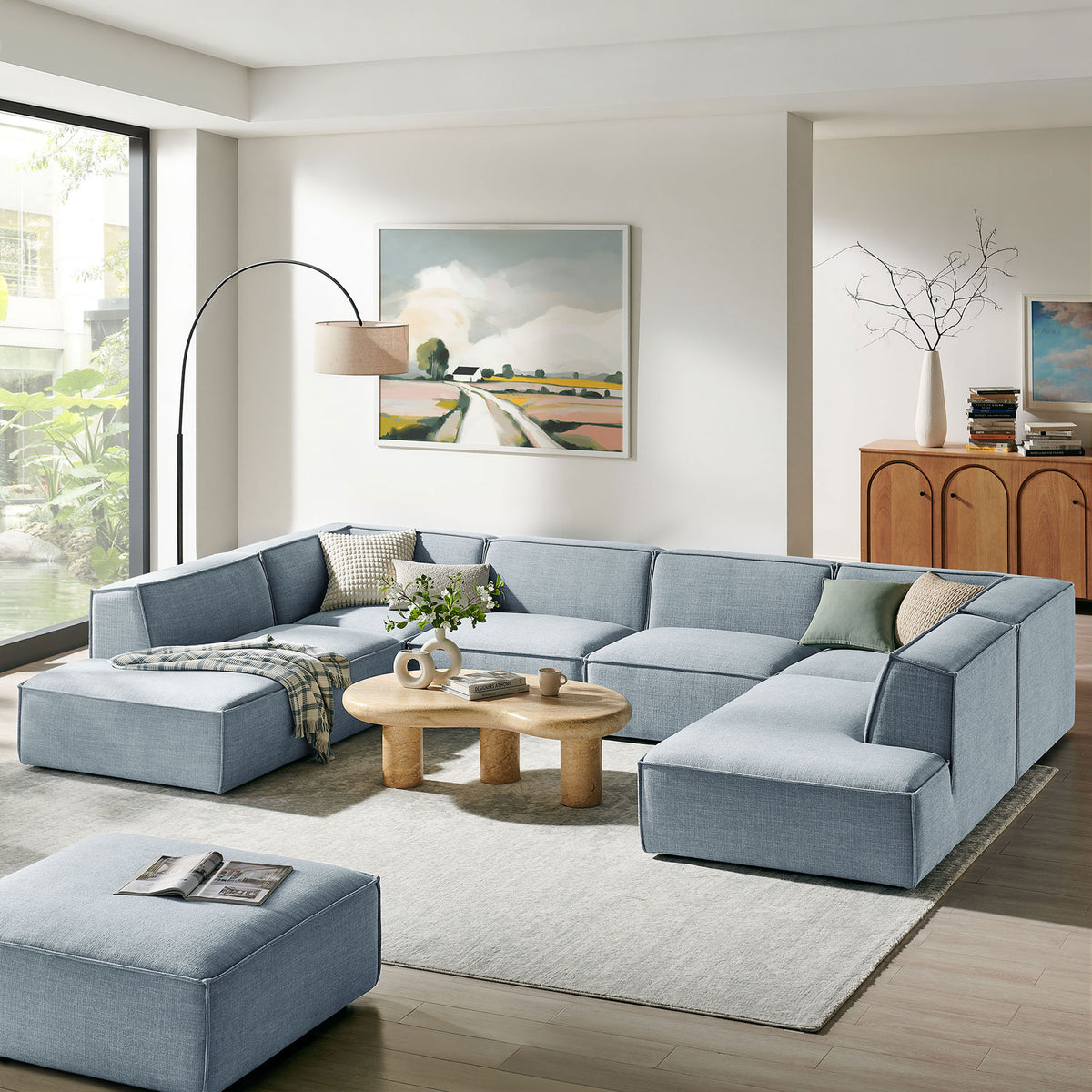Sky blue Restore modular sectional styled in a bright living room with neutral rug, wood tables, and greenery accents || EEI-7415-SKY || front_angle_room