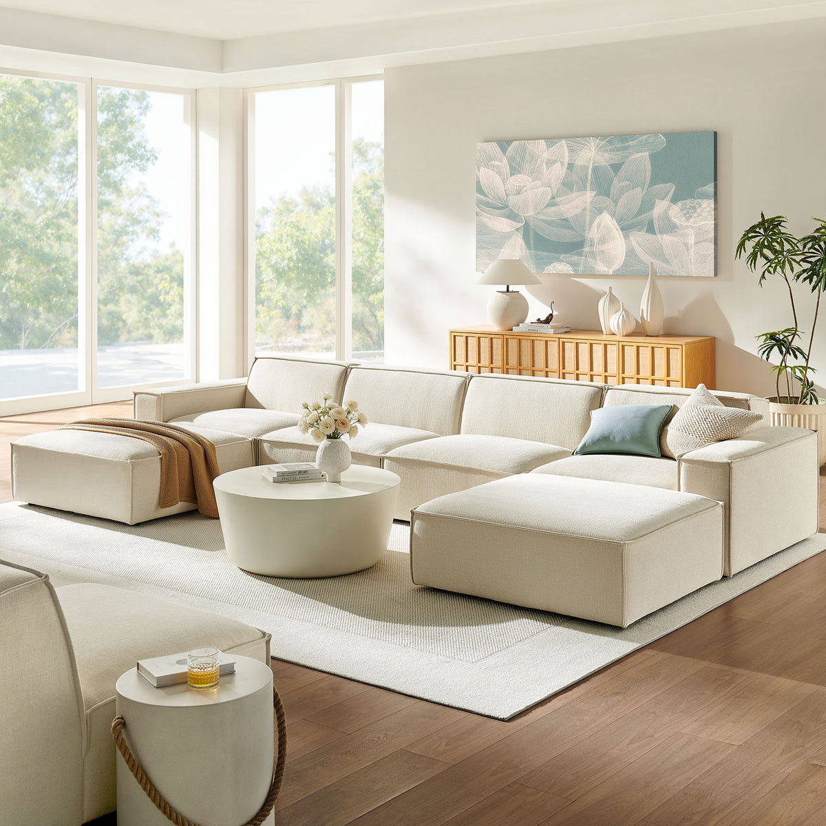 Ecru modular sectional styled in a bright living room with layered textures, pillows, and a coordinating ottoman || EEI-7417-ECR || front_angle_room
