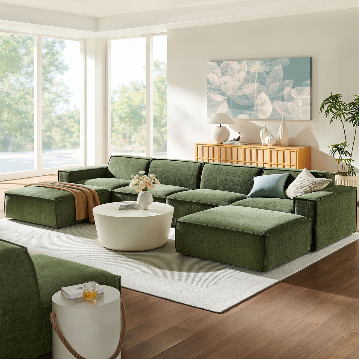 Restore foliage green modular sectional anchoring a bright living room with plush chaise-style seating and ottomans || EEI-7417-FOL || front_angle_room