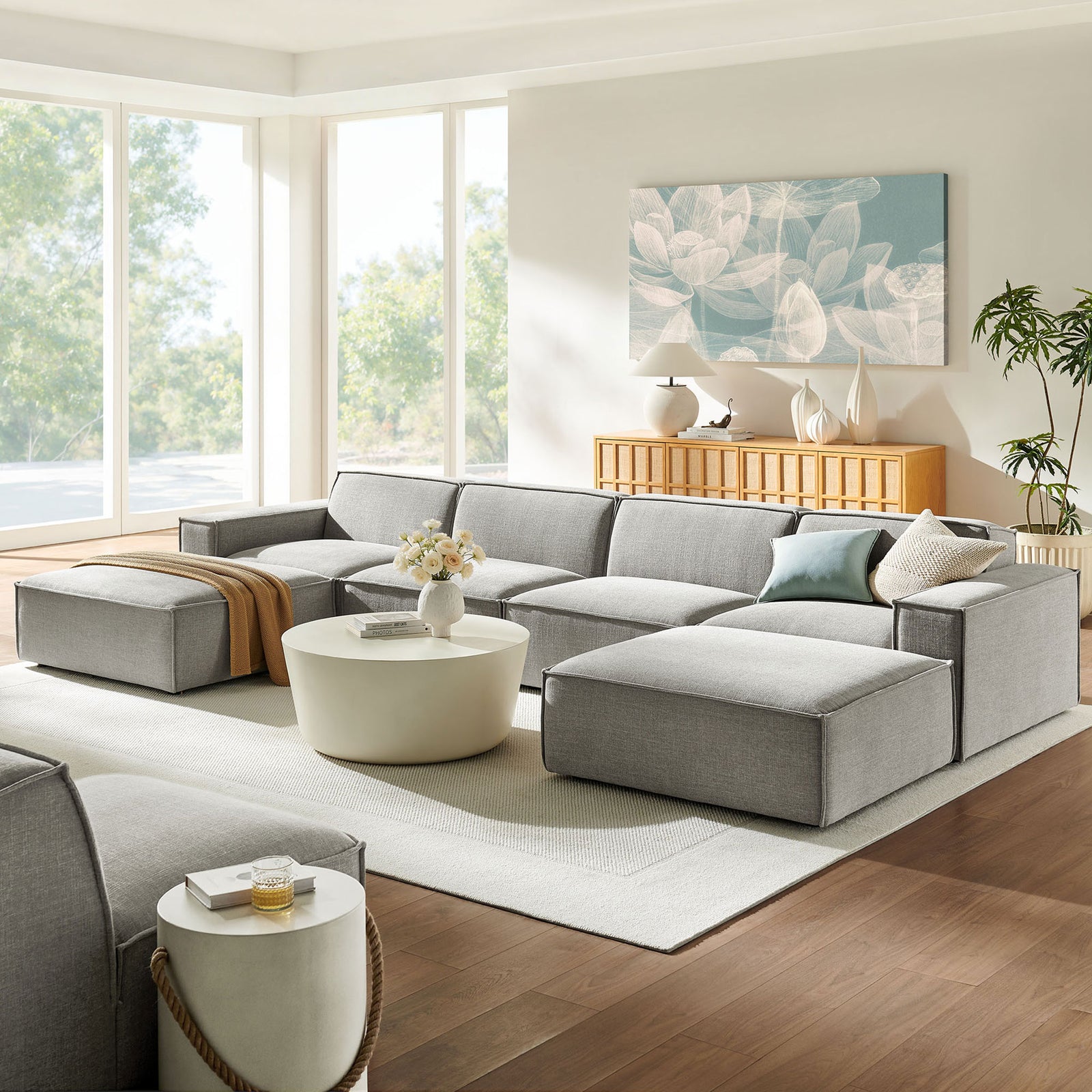 Restore pewter modular sectional arranged in a bright living room with two ottomans and low-profile seating || EEI-7417-PEW || front_angle_room