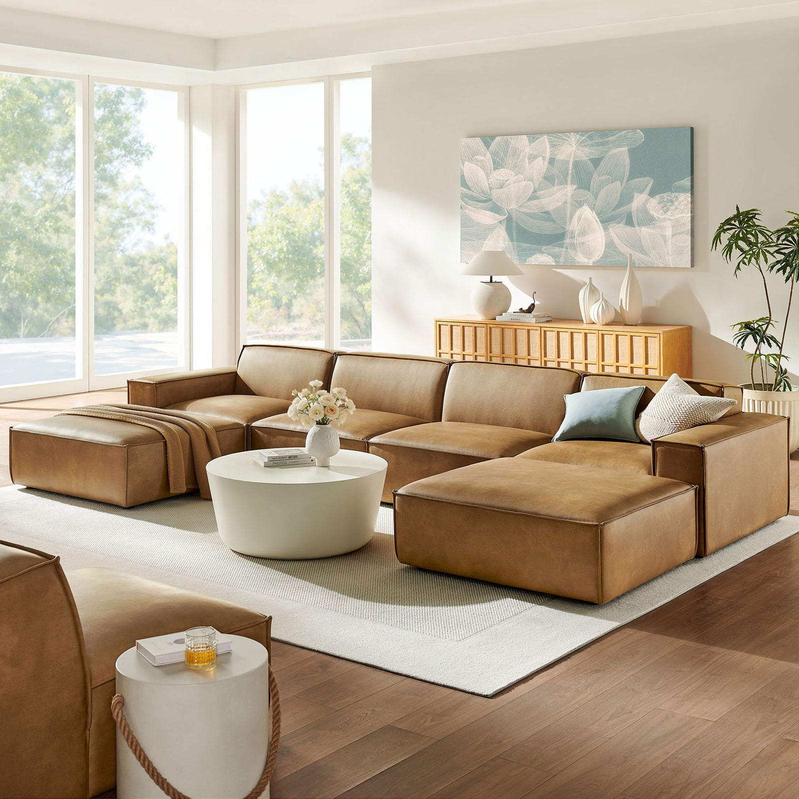 Modern living room featuring the Restore toast modular sectional paired with a round coffee table and soft accents. || EEI-7418-TST || front_angle_room