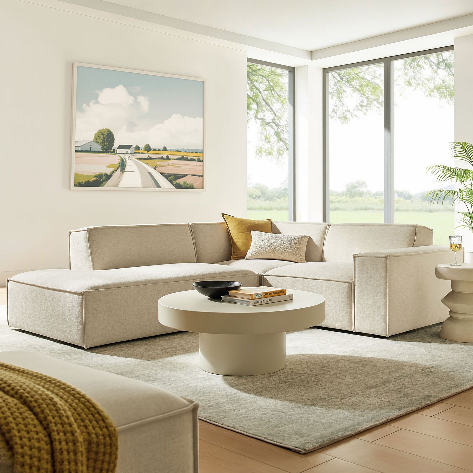 Neutral ecru modular sectional styled with accent pillows in a sunlit living room setting || EEI-7419-ECR || front_angle_room