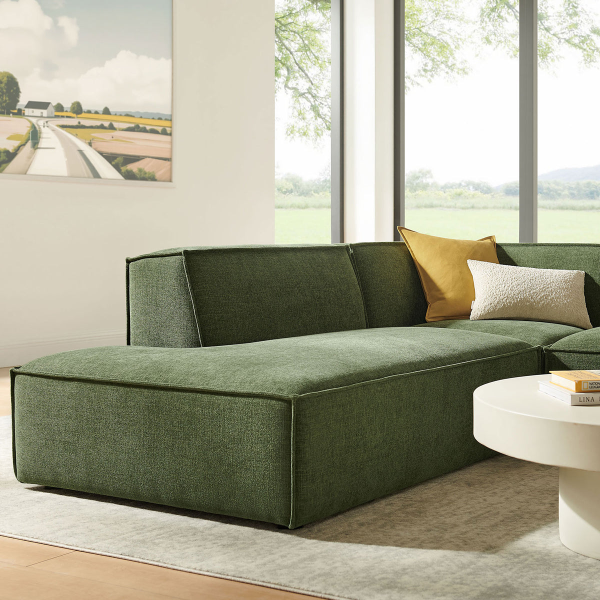 Extended chaise end of the green modular sectional styled by a large window with layered pillows and soft rug || EEI-7419-FOL || detail_room