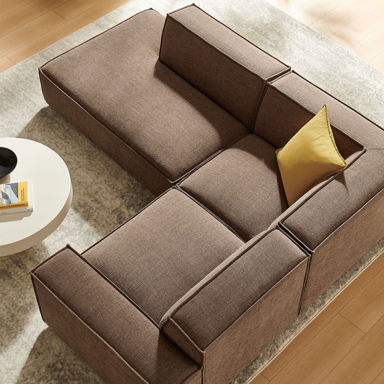 Mocha modular sectional and accent pillow bring soft texture and ample seating to a light-filled living space || EEI-7419-MOC || top_angle_room
