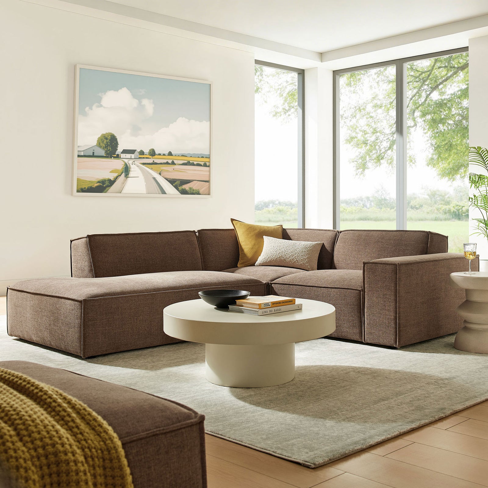 L-shaped mocha sectional pairs with a round coffee table to create a relaxed, contemporary living room setting || EEI-7419-MOC || front_angle_room