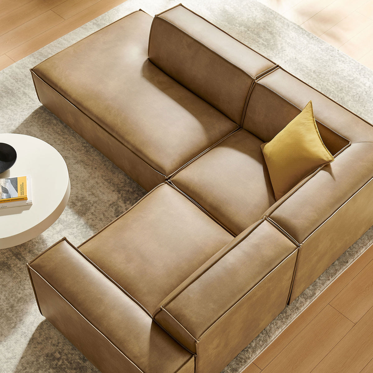 Modular toast vegan leather sectional and round coffee table styled to highlight the open seating layout || EEI-7420-TST || detail_room