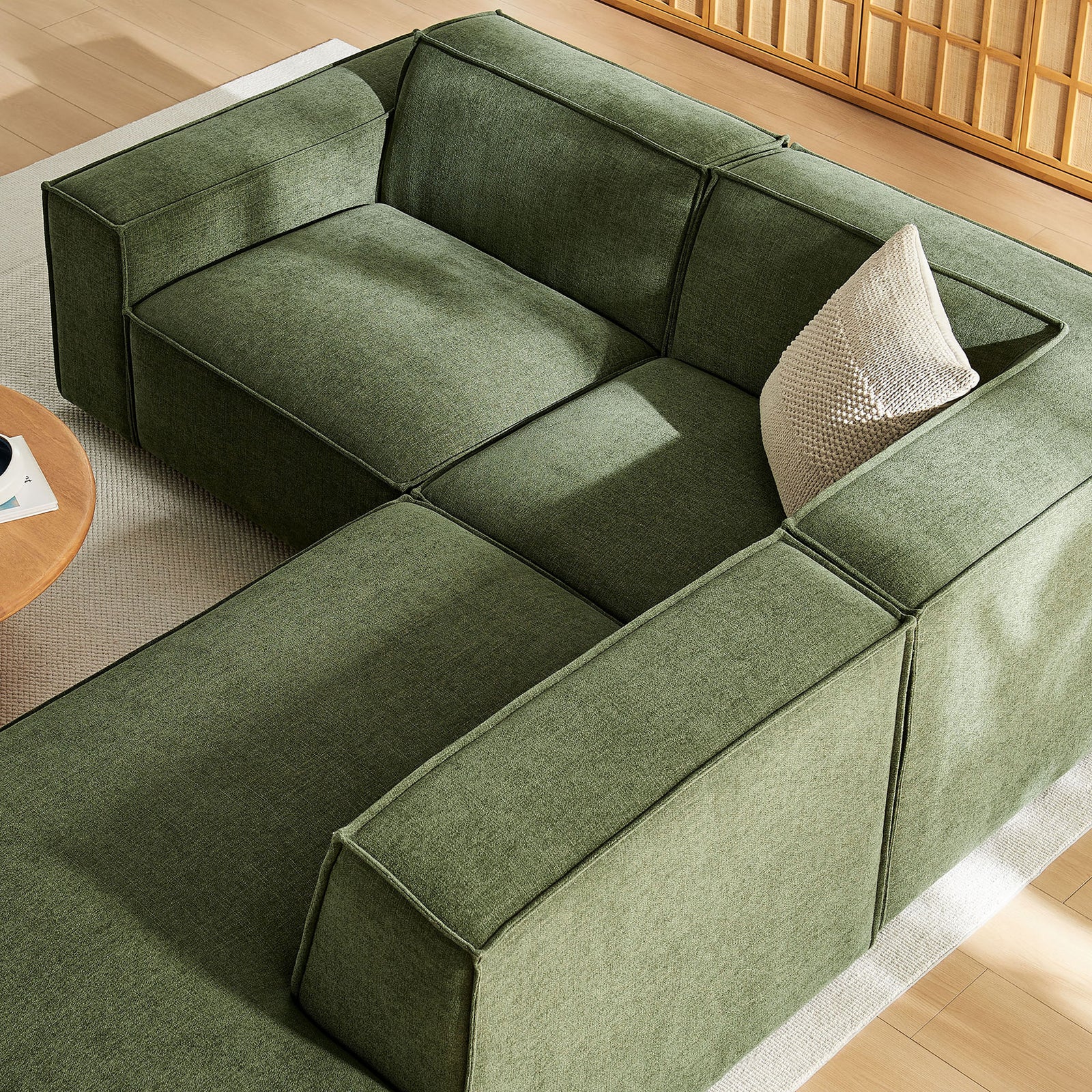 Tuftless seat cushions and tailored piping on the green modular sectional, styled with a knit accent pillow || EEI-7421-FOL || detail_room