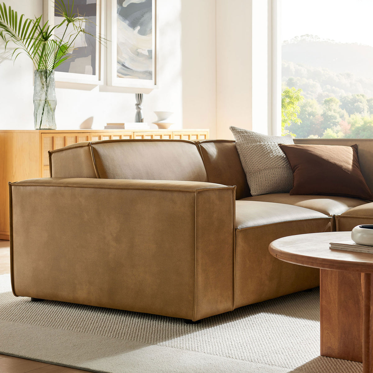 Close-up of the toast vegan leather sectional arm and seat highlighting smooth upholstery and tailored piping || EEI-7422-TST || detail_room