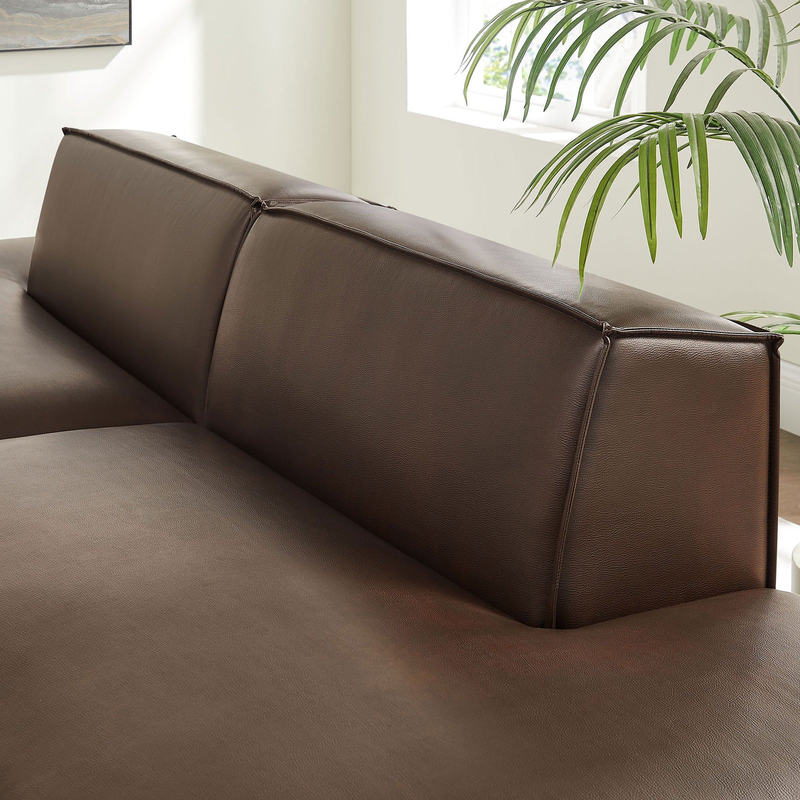 Detail of the low-profile back cushions showing smooth vegan leather texture and refined French piping || EEI-7424-ESP || detail_room