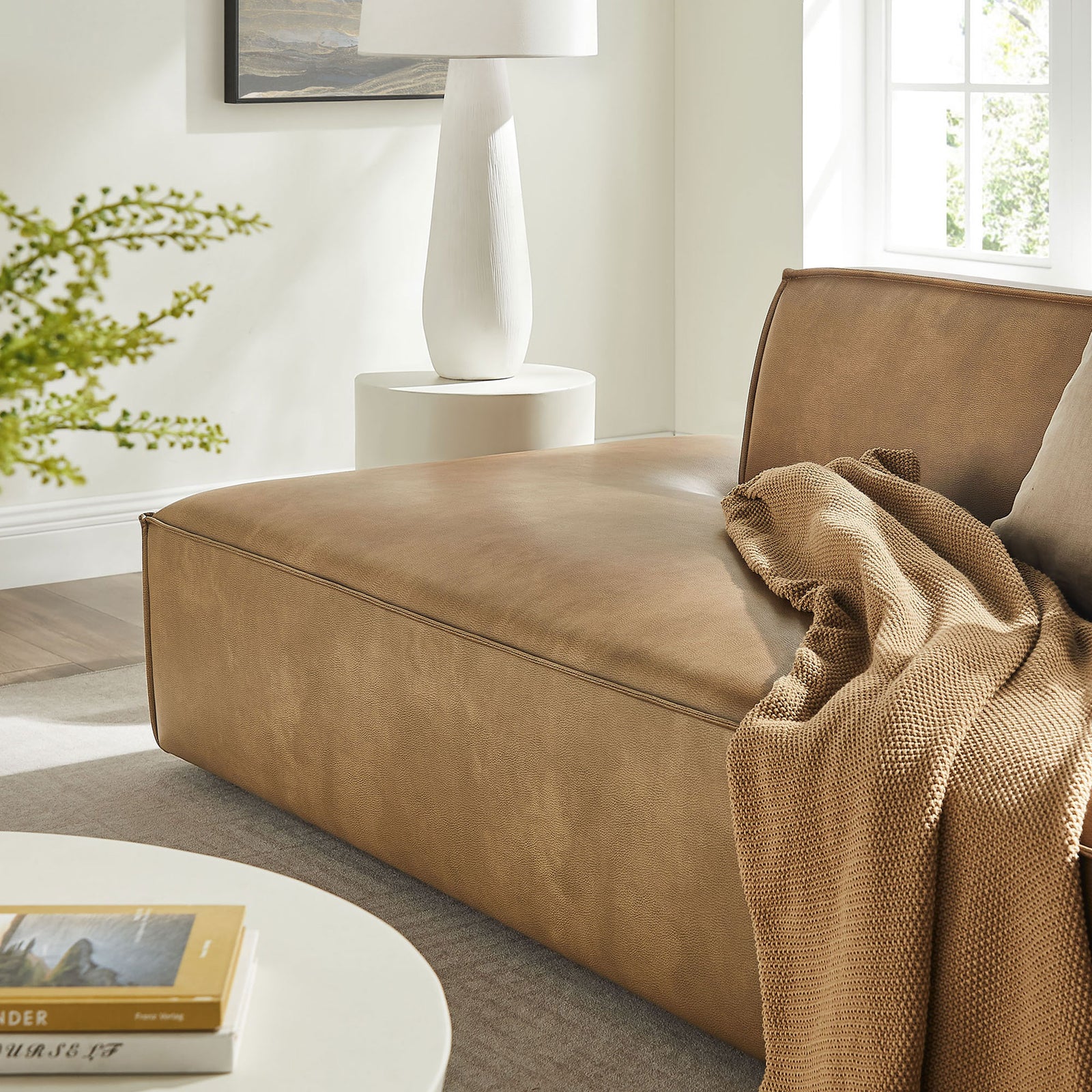Cozy chaise seat in toast vegan leather styled with a textured throw for relaxed lounging comfort. || EEI-7424-TST || detail_room