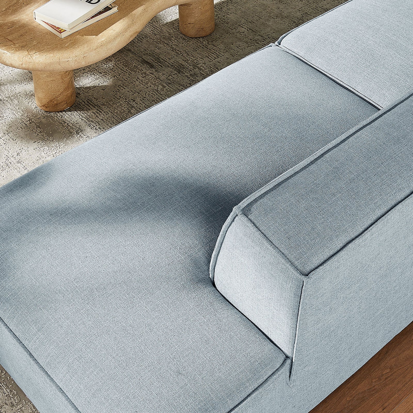 Soft performance fabric and generous seat cushions create a cozy lounge spot beside the sculpted wood coffee table || EEI-7425-SKY || detail_room